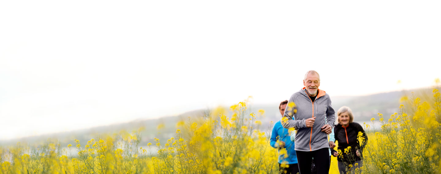 Healthy, senior man running with group of friends