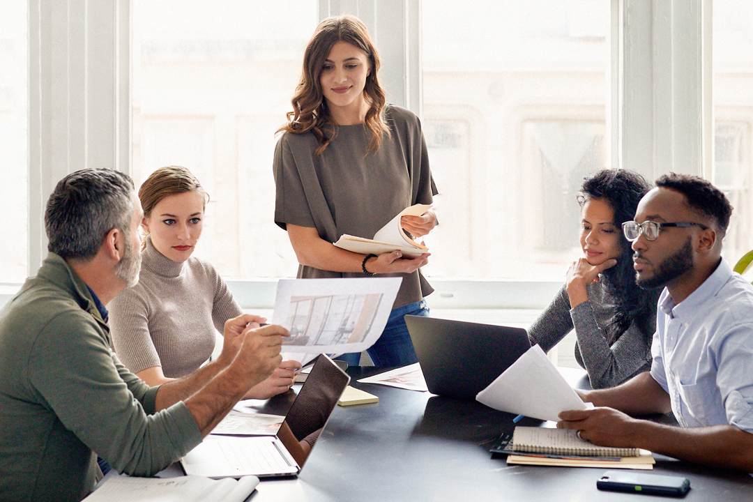 Group of people sitting around a conference table in a business meeting 